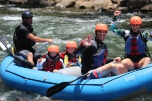 Rafting team paddling through Class II–III rapids near Arenal Volcano